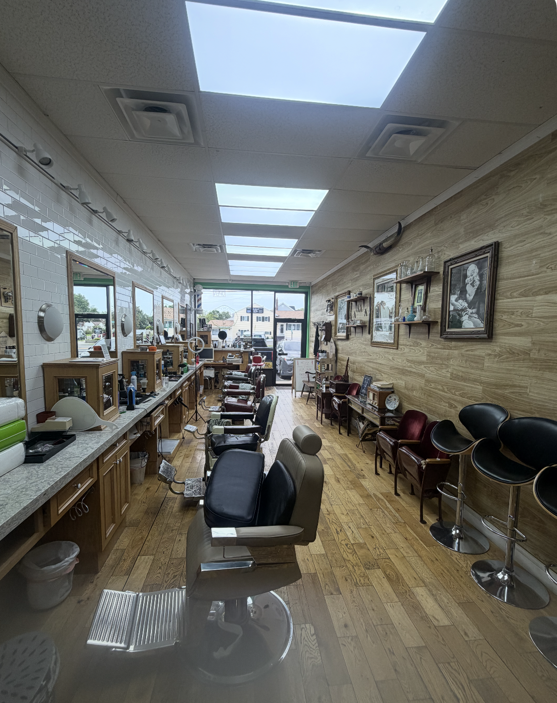 The Silent Barber &mdash; looking toward the front window, waiting chairs and stools along the wall
